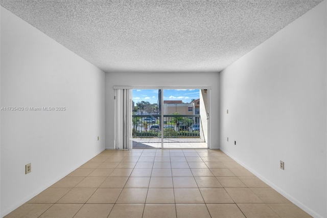 tiled spare room featuring a textured ceiling