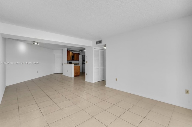 interior space featuring a textured ceiling and light tile patterned floors