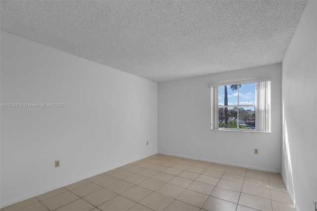 tiled empty room featuring a textured ceiling