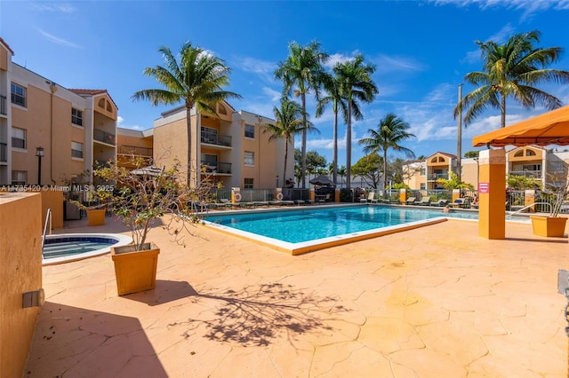 view of pool with a hot tub and a patio