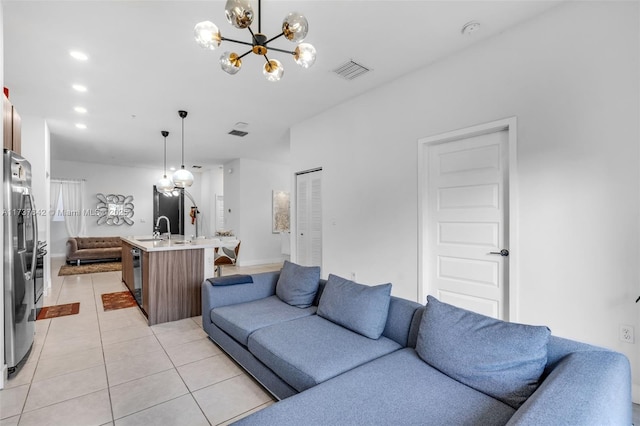 living room featuring sink, light tile patterned floors, and an inviting chandelier