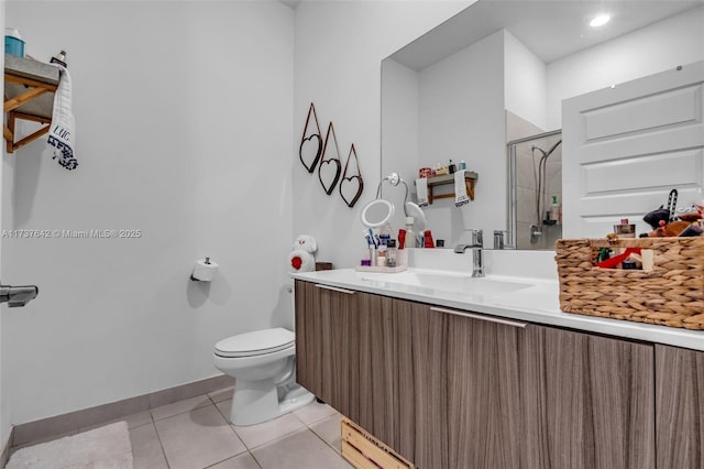 bathroom with vanity, a shower with shower door, tile patterned floors, and toilet