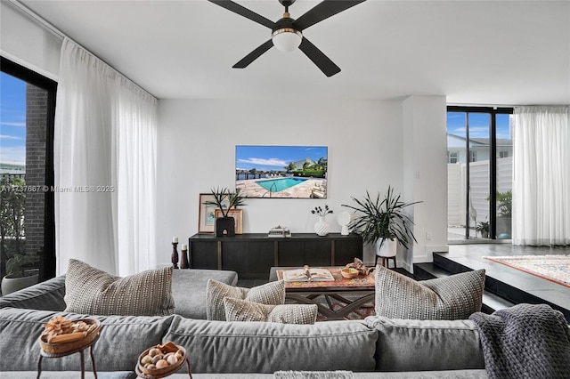 living room with expansive windows and ceiling fan