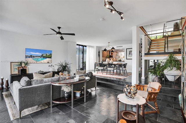 living room featuring expansive windows and ceiling fan