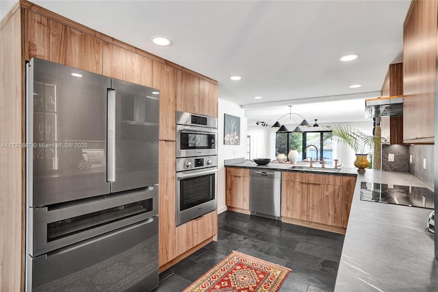 kitchen with appliances with stainless steel finishes, sink, decorative backsplash, and kitchen peninsula