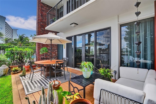 view of patio with an outdoor living space, a balcony, and french doors