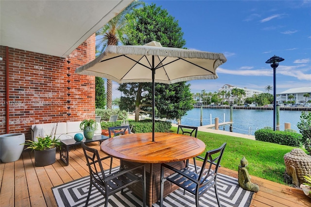 wooden terrace with a water view and a yard