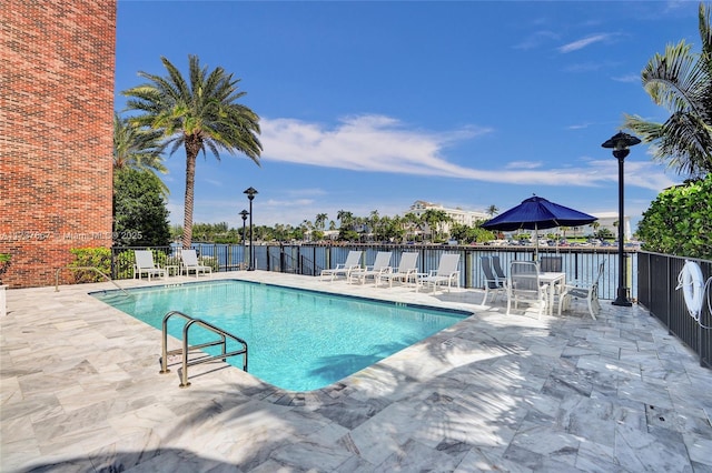 view of swimming pool with a water view and a patio area