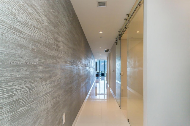 hallway with expansive windows and light tile patterned flooring