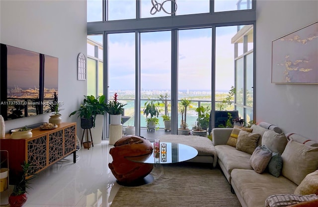 living room featuring a towering ceiling and a water view