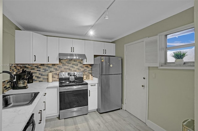 kitchen with white cabinetry, sink, backsplash, light stone counters, and stainless steel appliances