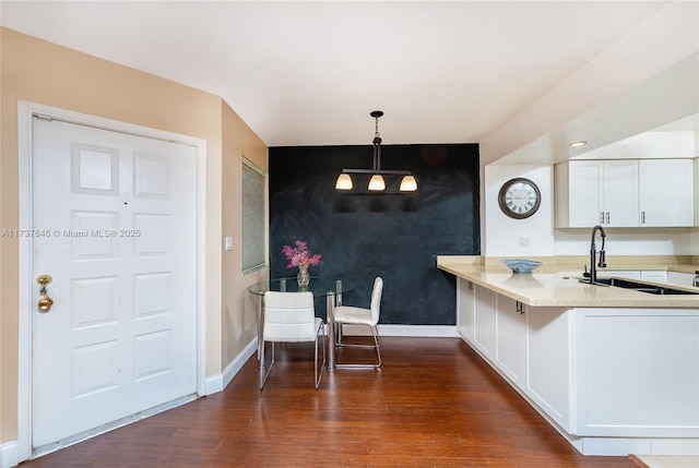 kitchen with white cabinetry, sink, dark hardwood / wood-style flooring, and decorative light fixtures