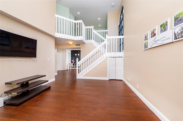 interior space with hardwood / wood-style flooring and a towering ceiling