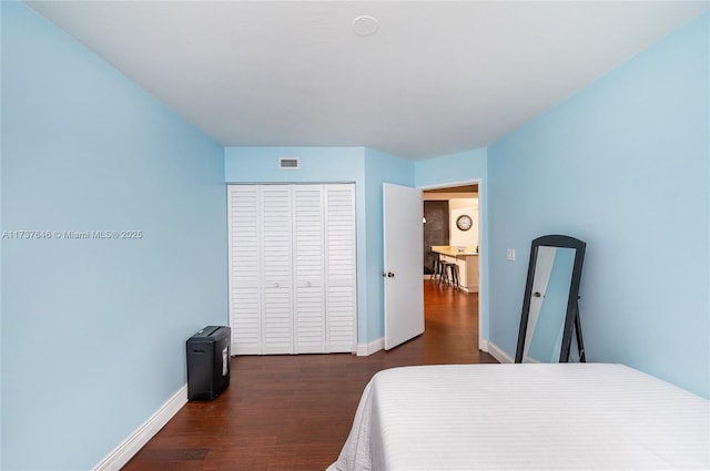 bedroom featuring dark wood-type flooring and a closet