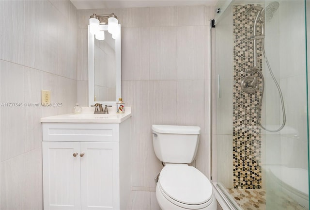 bathroom featuring tile walls, vanity, toilet, and walk in shower