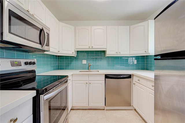 kitchen featuring stainless steel appliances, sink, white cabinets, and backsplash