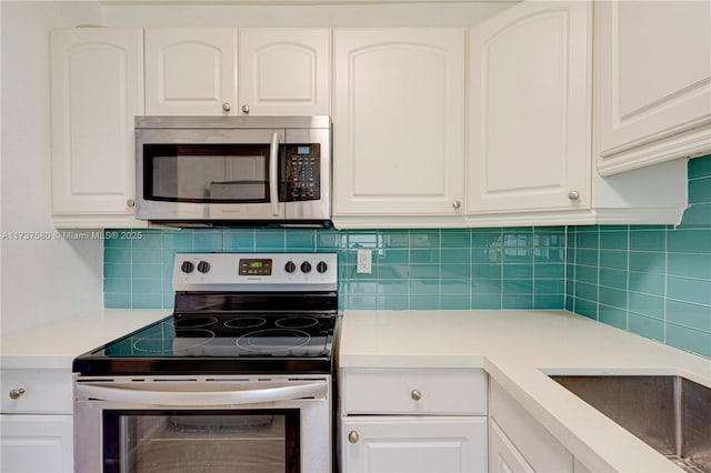 kitchen featuring white cabinetry, stainless steel appliances, sink, and decorative backsplash