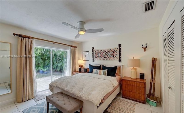 bedroom featuring ceiling fan, light tile patterned floors, a textured ceiling, and access to outside