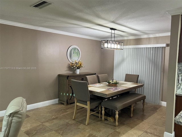 dining area with ornamental molding and a textured ceiling