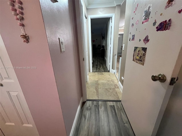 corridor with hardwood / wood-style flooring and crown molding