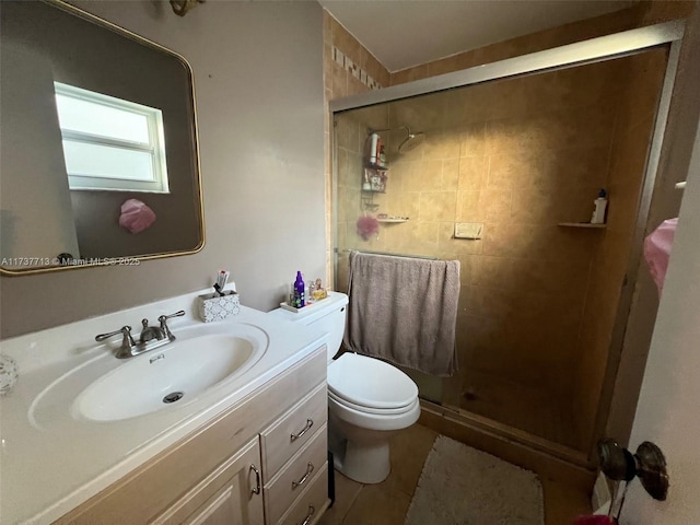 bathroom with tile patterned flooring, vanity, toilet, and walk in shower