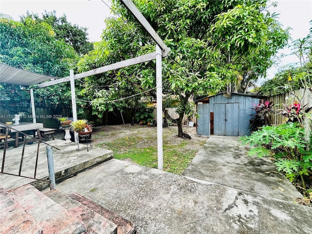 view of yard featuring a storage shed and a patio