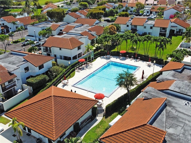 view of swimming pool featuring a residential view, fence, and a patio