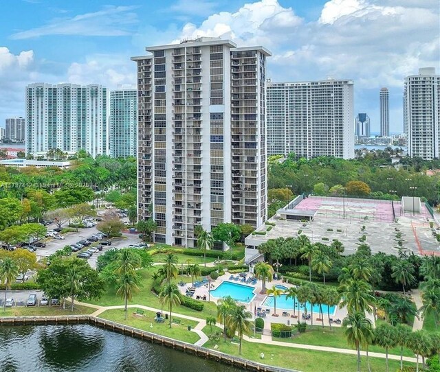 view of building exterior with a water view and a community pool