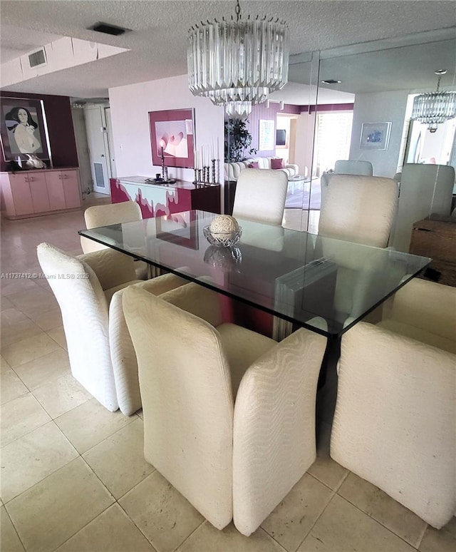 dining space featuring an inviting chandelier, visible vents, and a textured ceiling