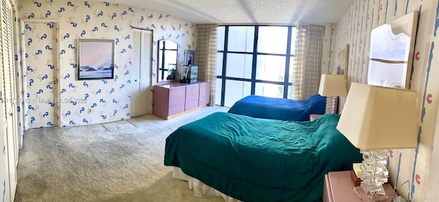 carpeted bedroom featuring wallpapered walls and a textured ceiling