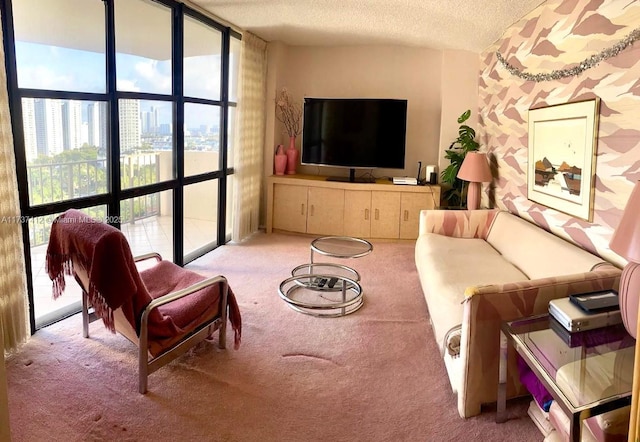 living area featuring expansive windows, a textured ceiling, and carpet flooring