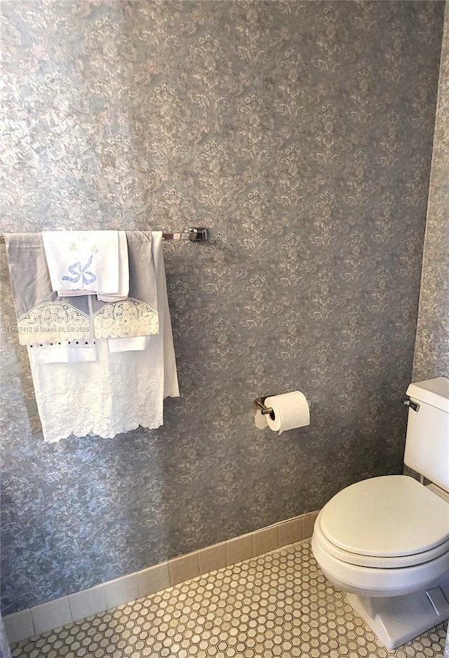 bathroom with baseboards, toilet, and tile patterned floors