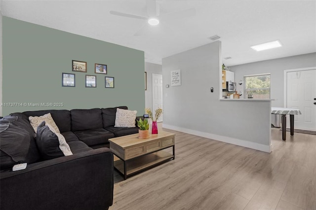 living room featuring light hardwood / wood-style flooring and ceiling fan