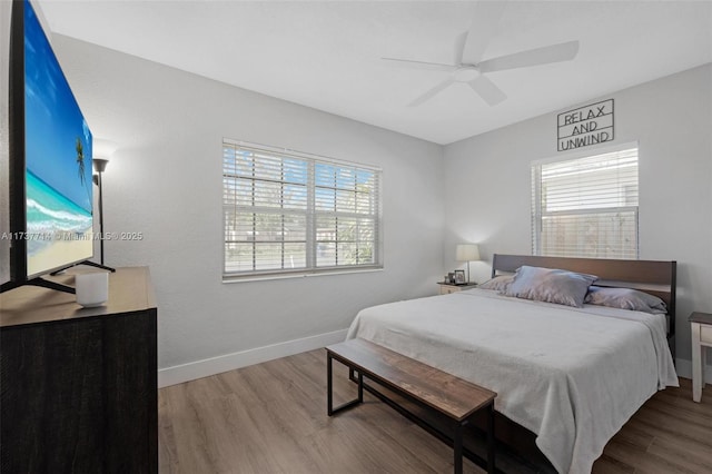 bedroom with multiple windows, hardwood / wood-style floors, and ceiling fan