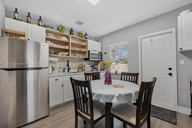 dining room with sink and light hardwood / wood-style flooring