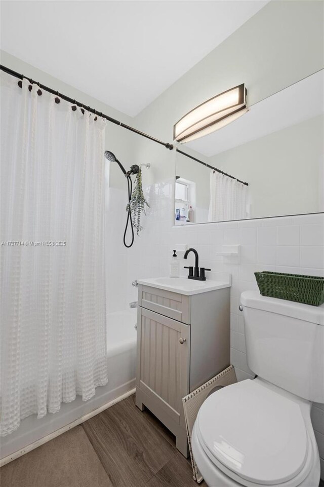 full bathroom featuring vanity, tile walls, washtub / shower combination, and toilet