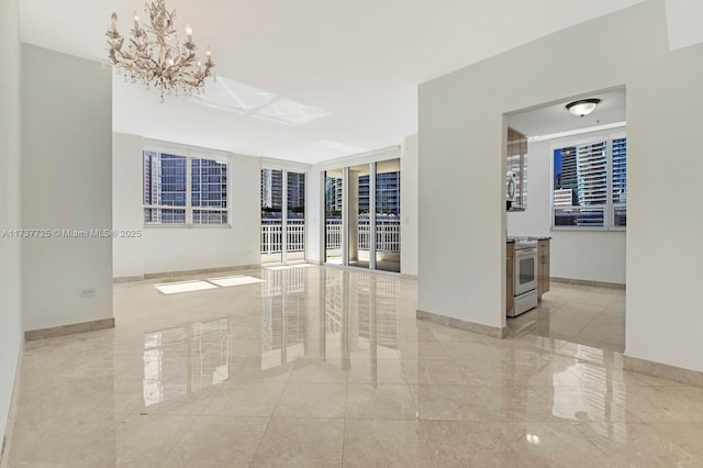 spare room featuring an inviting chandelier and floor to ceiling windows