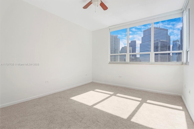 empty room featuring light colored carpet and ceiling fan