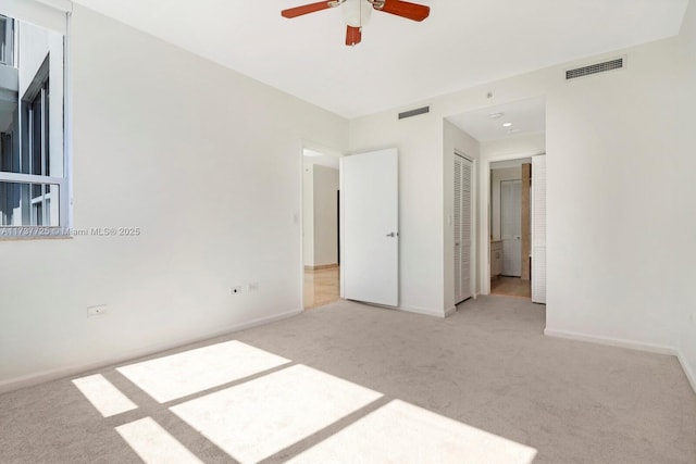 unfurnished bedroom featuring light colored carpet, a closet, and ceiling fan