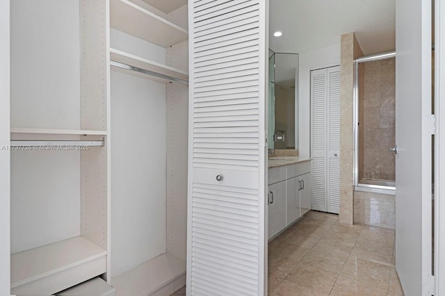 interior space featuring vanity, a shower, and tile patterned floors