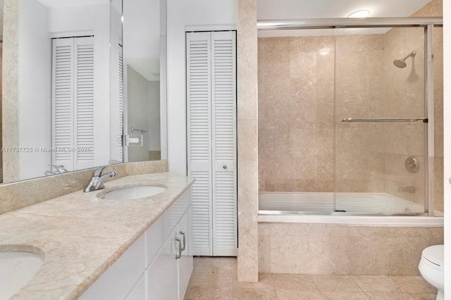 full bathroom featuring toilet, vanity, shower / bath combination with glass door, and tile patterned flooring