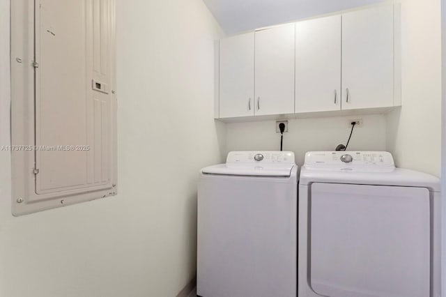 clothes washing area featuring cabinets, electric panel, and washing machine and dryer