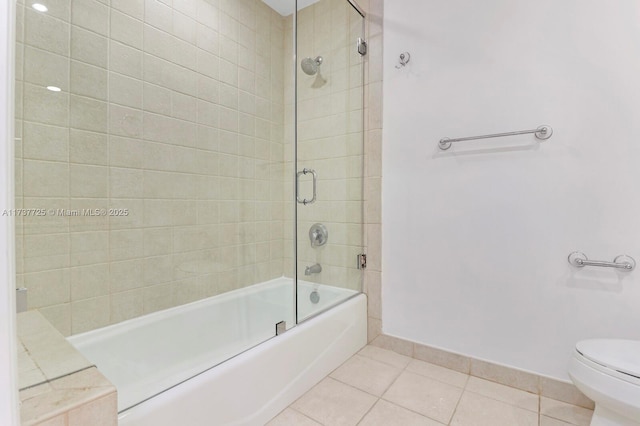 bathroom with bath / shower combo with glass door, toilet, and tile patterned flooring