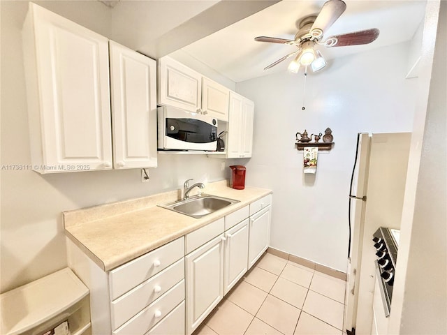 kitchen featuring sink, white cabinetry, light tile patterned floors, ceiling fan, and white appliances