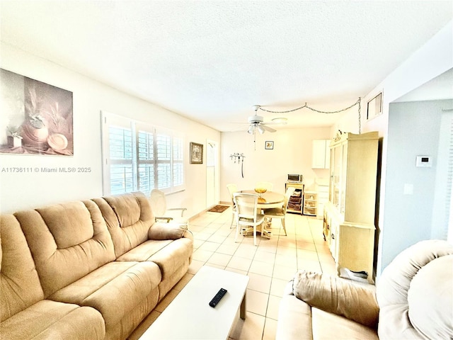 tiled living room featuring ceiling fan and a textured ceiling