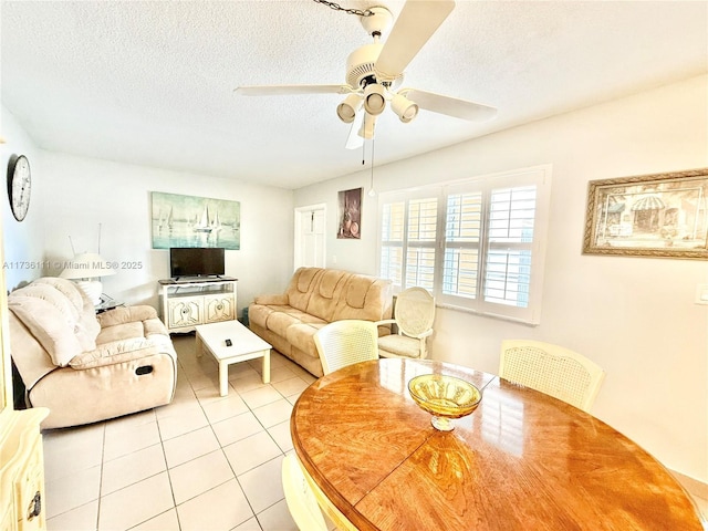 living room featuring ceiling fan, a textured ceiling, and light tile patterned floors