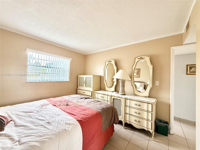 bedroom with a textured ceiling and light tile patterned floors