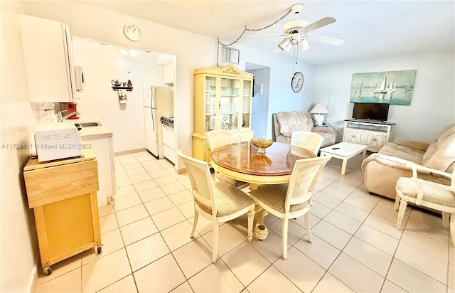 dining area with light tile patterned flooring, sink, a textured ceiling, and ceiling fan