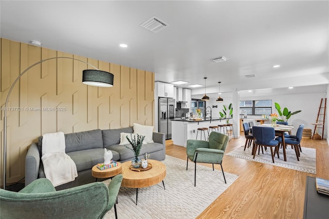 living room with sink and light hardwood / wood-style floors