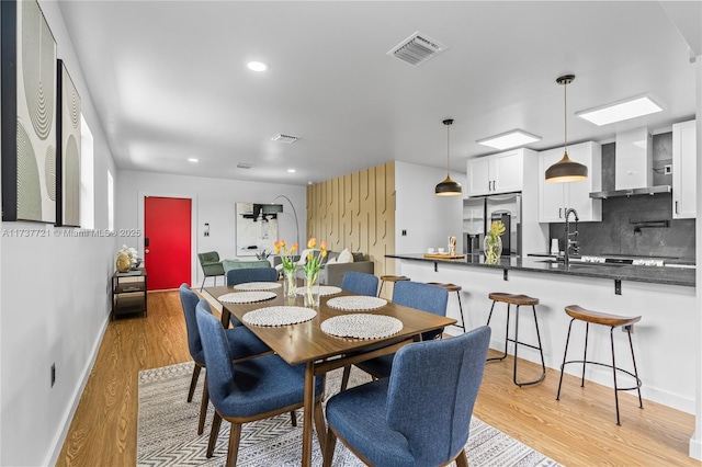 dining space featuring sink and light wood-type flooring